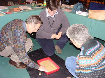 Three teachers explore tactile craters on a simulated moon surface